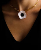 petit pendentif blanc porté dans un decolleté all-groups