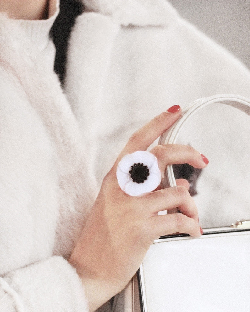 bague anémone blanche portée sur une femme tenant un miroir all-groups