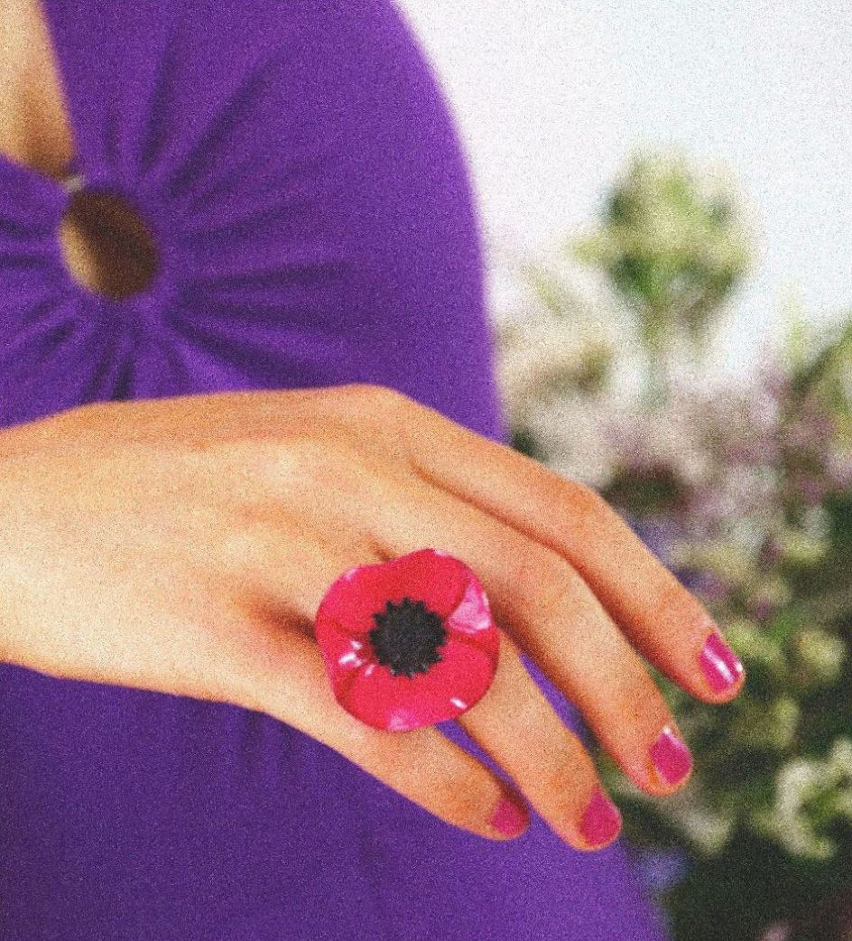 Bague rose anemone sur main avec du vernis rose 