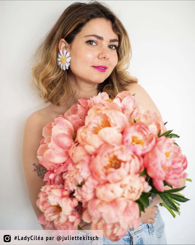 femme avec des pivoines portant des bijoux marguerite