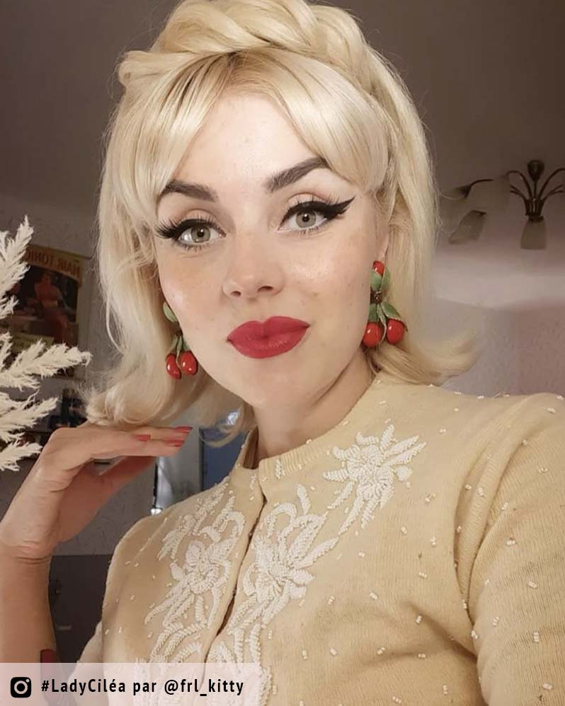 femme blonde avec boucles d'oreilles cerise