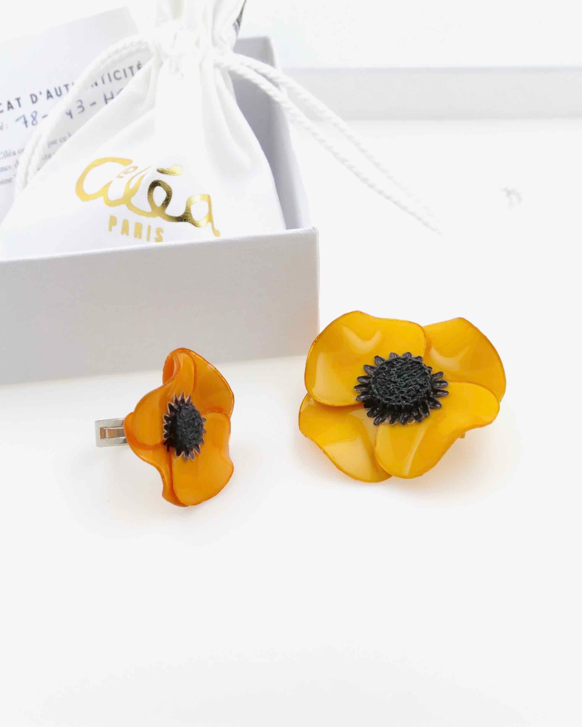 Broche jaune avec une bague orange clair dans un coffret 