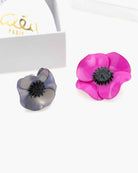 Broche fuschia avec une bague bleu irisée dans un coffret