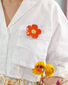 all-groups Grande broche tuba orange portee sur une chemise blanche