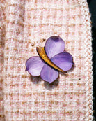 all-groups Broche zora violette portée sur une veste en tweed rosepale