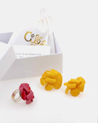 coffret cadeau avec une paire de boucles d'oreilles jaunes et une bague rouge 