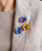 all-groups Trois pin's fleurs colorés sur une veste en lin beige