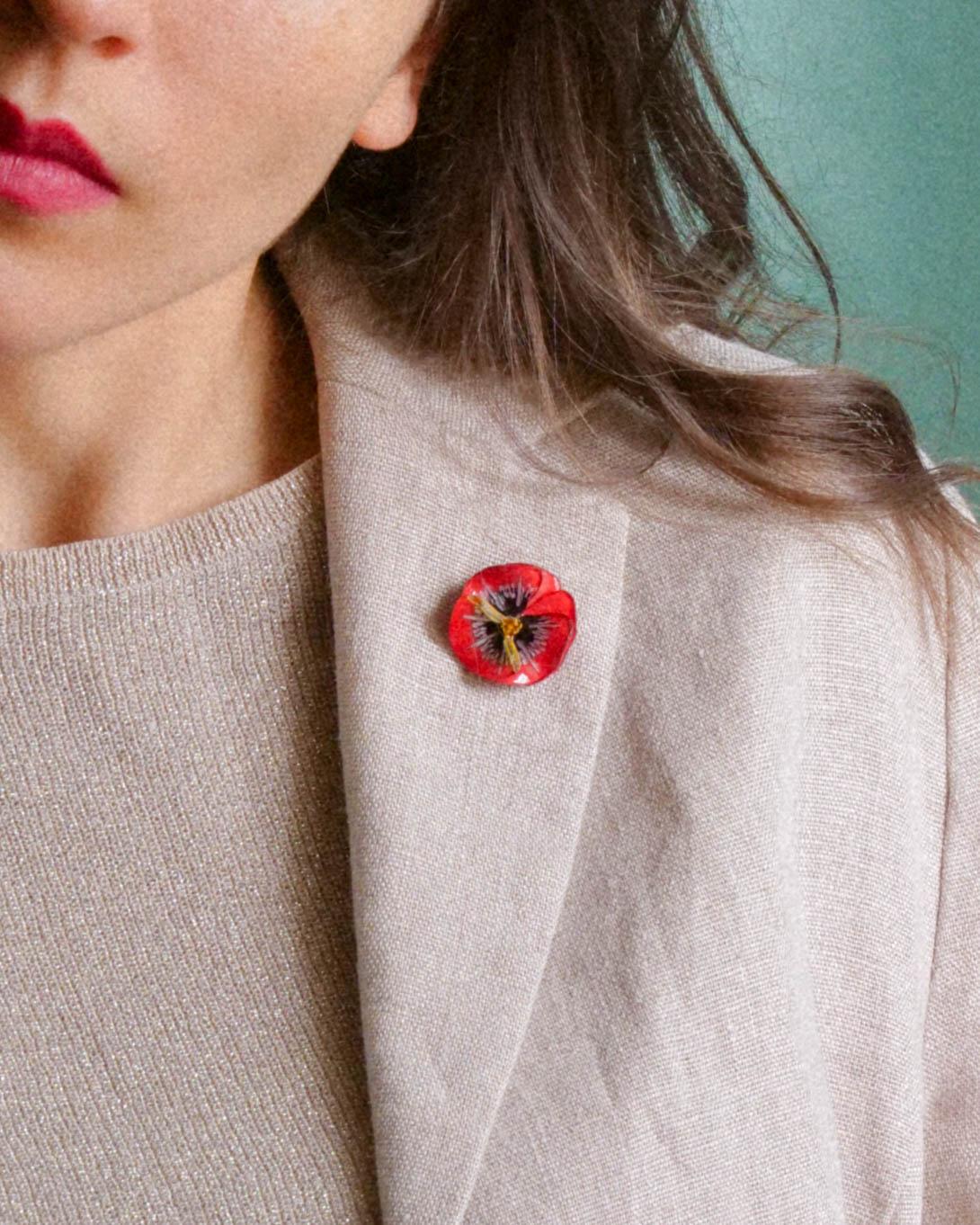 all-groups P'ins bijoux fait en france rouge fleur porté par une femme sur un blazer en lin beige clair