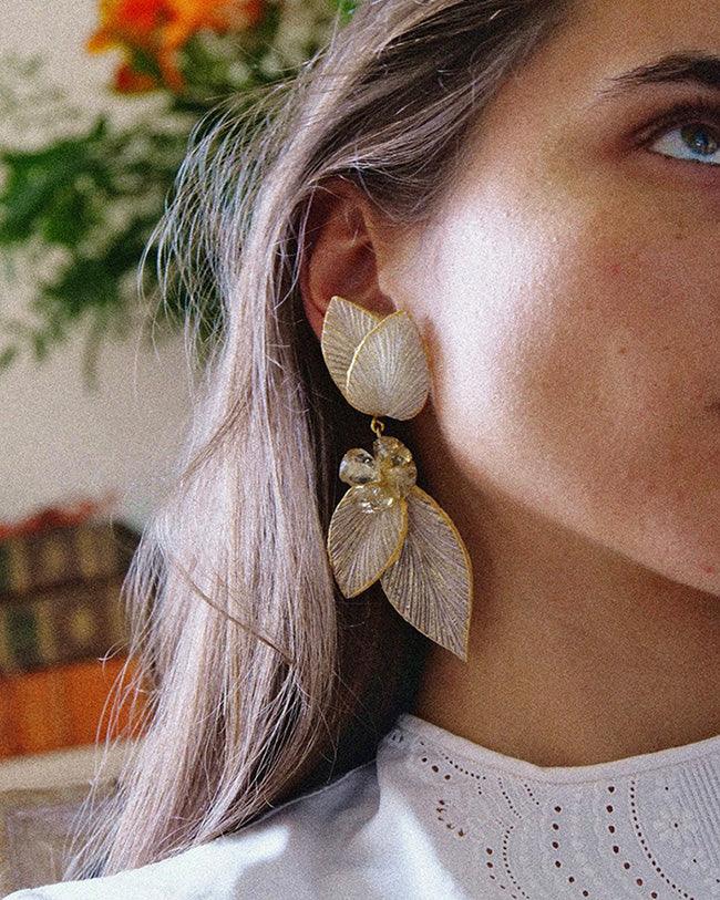 Boucles d'oreilles dorées portées sur une femme