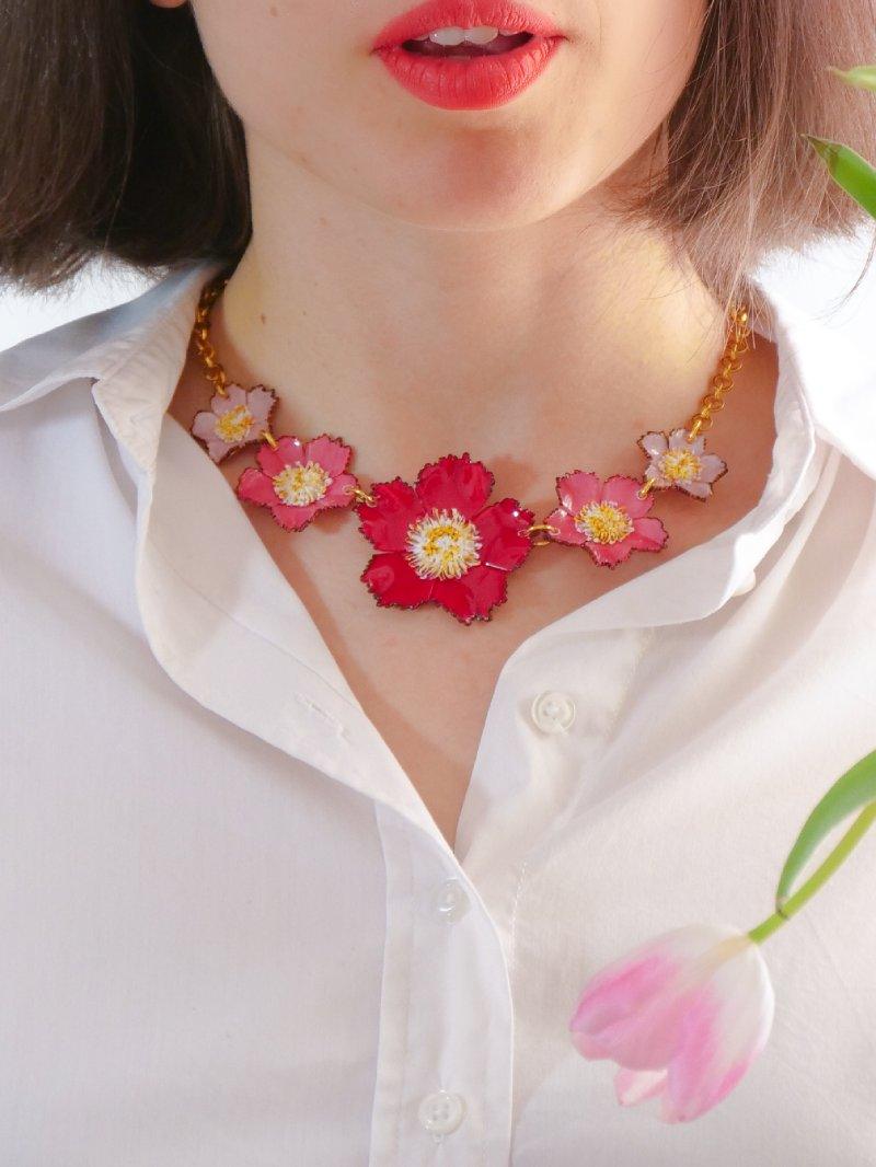 petit collier tuba rouge et rose porté avec une chemise blanche all-groups